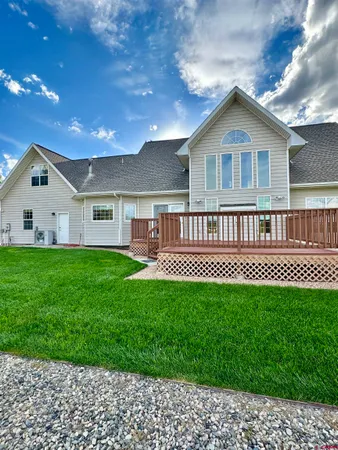 a view of a house with a yard and deck