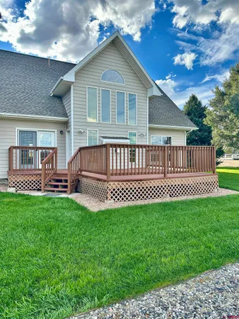 a view of a house with a yard and deck