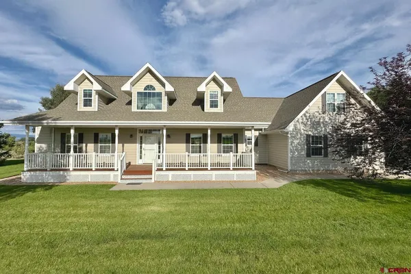 a front view of house with yard outdoor seating and garage