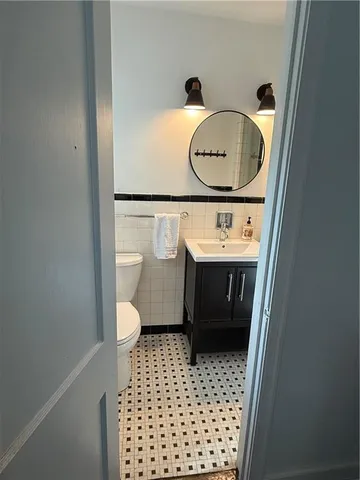 a bathroom with a granite countertop toilet sink and mirror