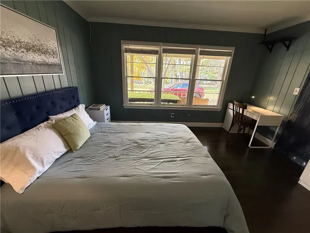a large bed sitting in a bedroom next to a window