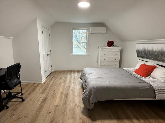 a bedroom with a bed and wooden floor