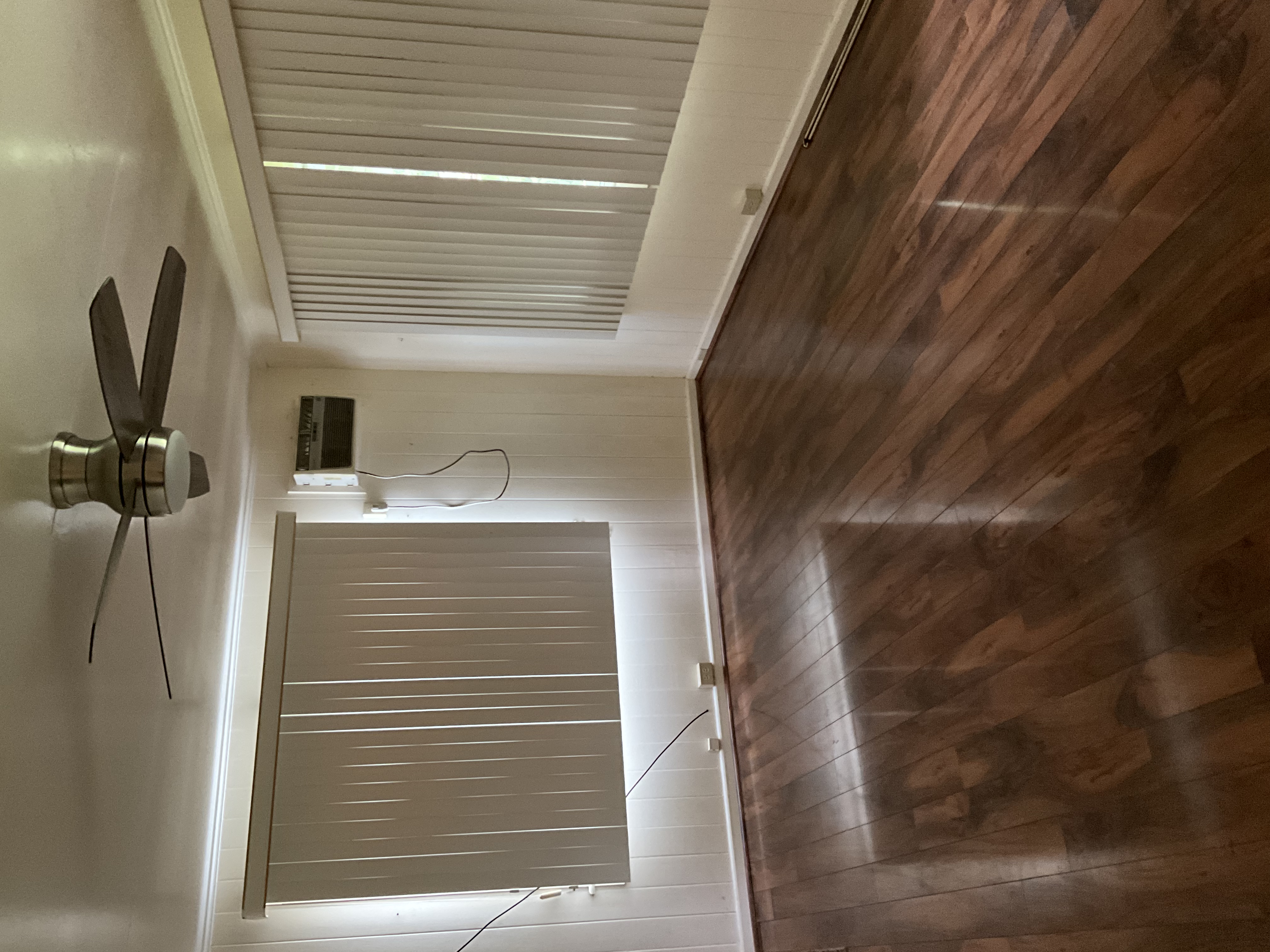 568 Kalanikoa Street, Unit 2 Hilo, HI 96720 - Photo 18 of 24 a view of an empty room with wooden floor and a window