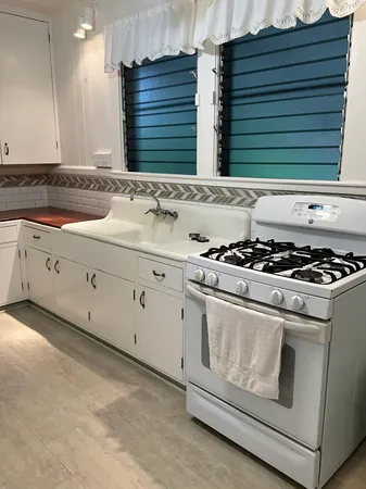a kitchen with granite countertop white cabinets and white appliances