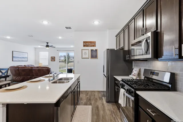 a kitchen with stainless steel appliances granite countertop a stove a refrigerator a sink a stove and island