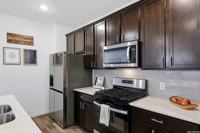 a kitchen with stainless steel appliances granite countertop a refrigerator stove and sink