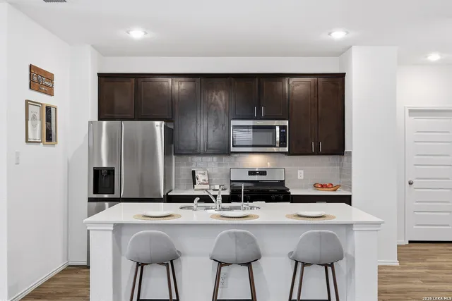 a kitchen with appliances a sink cabinets and wooden floor