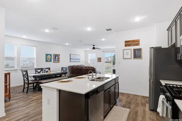 a kitchen that has a sink a table and chairs in it