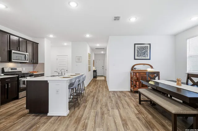 a kitchen with a sink appliances and wooden floor