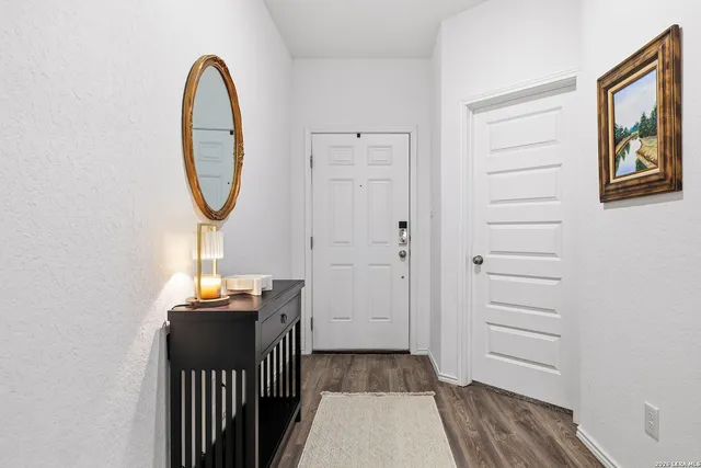a view of a hallway with wooden floor and entryway