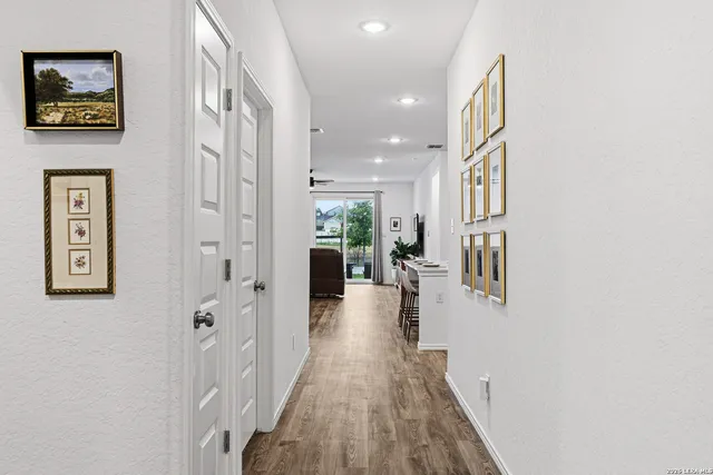 a view of a hallway with wooden floor and windows