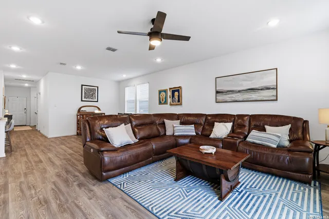 a living room with furniture and a ceiling fan