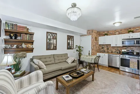 a living room with furniture a rug and kitchen view