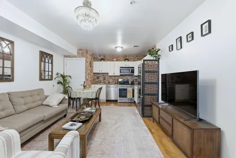 a living room with furniture kitchen view and a flat screen tv