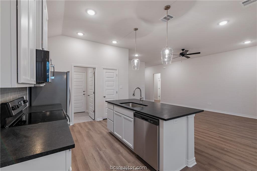 3161 Tarleton Court Bryan, TX 77808 - Photo 10 of 23 a kitchen with stainless steel appliances granite countertop a sink stove and refrigerator