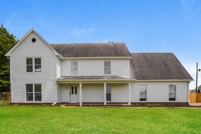 a front view of a house with a garden and yard