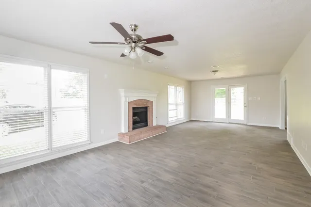 a view of an empty room with a window and fireplace