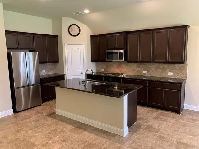 a kitchen with granite countertop stainless steel appliances and wooden cabinets
