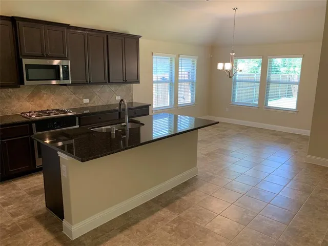 a kitchen with stainless steel appliances granite countertop a stove and a microwave