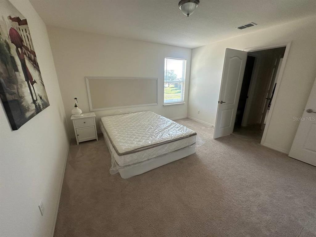 3877 Mount Vernon Way Kissimmee, FL 34741 - Photo 12 of 27 a spacious bedroom with a bed and a window
