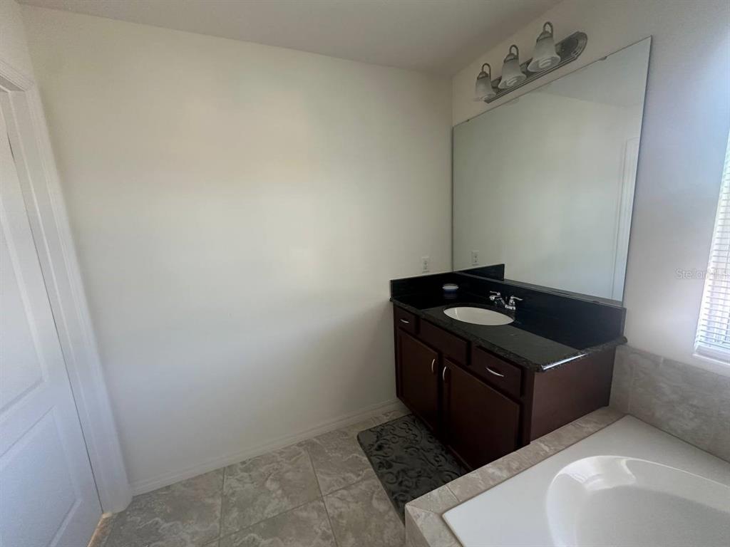 3877 Mount Vernon Way Kissimmee, FL 34741 - Photo 15 of 27 a bathroom with a sink and a mirror