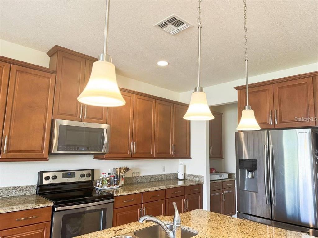 3877 Mount Vernon Way Kissimmee, FL 34741 - Photo 3 of 27 a kitchen with a sink a counter and cabinets