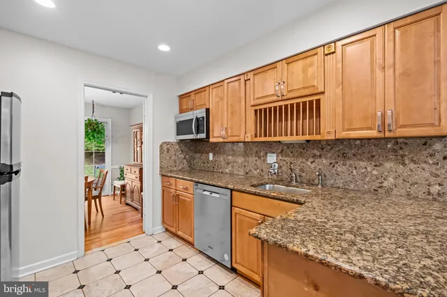 a view of kitchen with granite countertop cabinets table and chairs