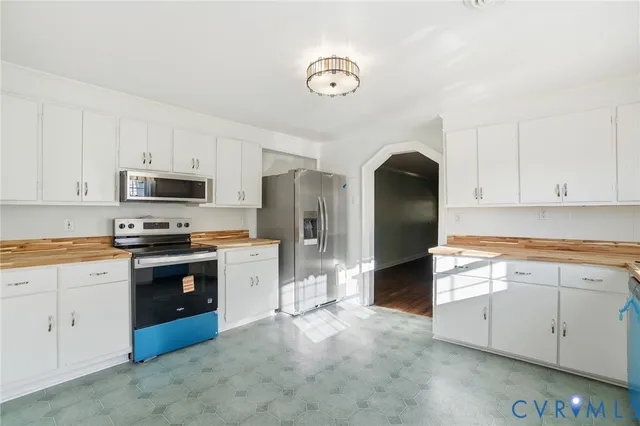 a kitchen with granite countertop a refrigerator stove and sink