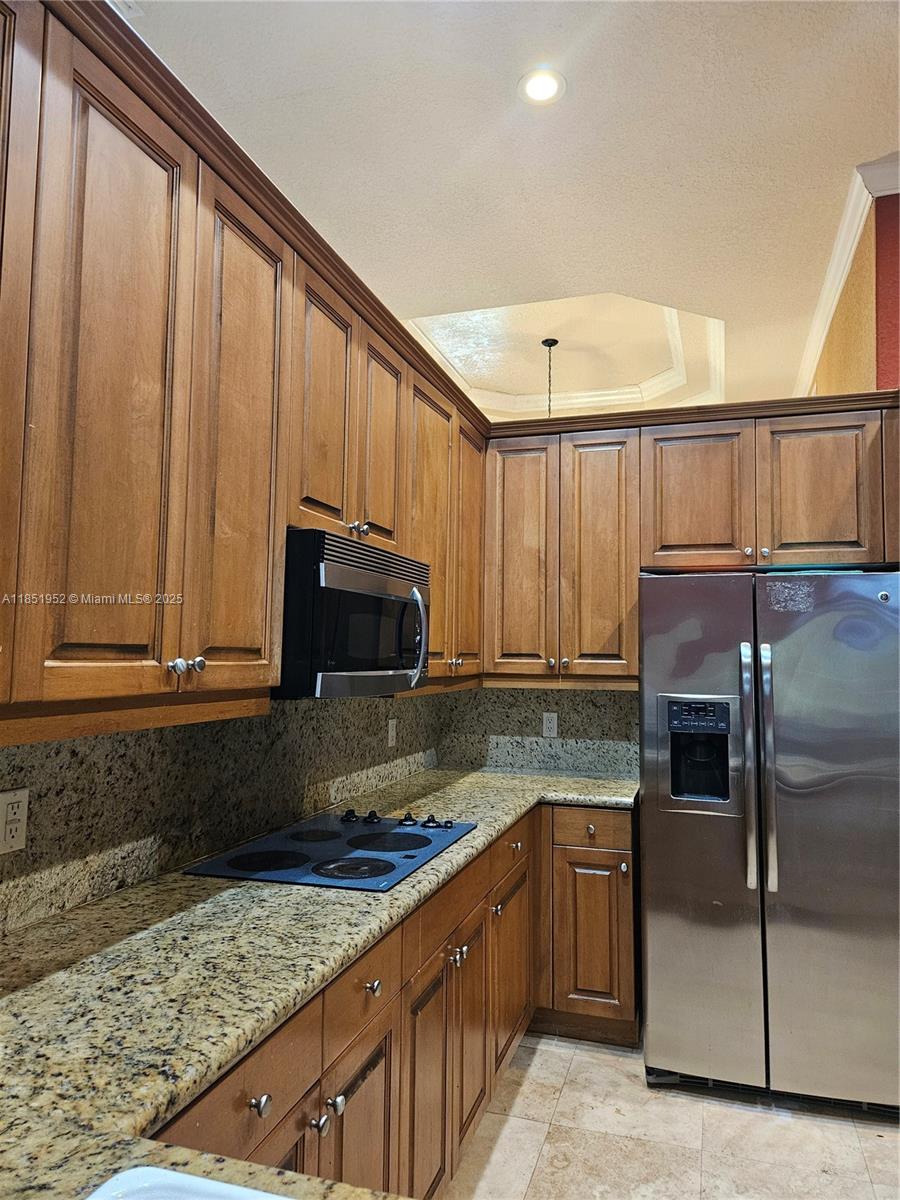 18951 Southwest 30th Street Miramar, FL 33029 - Photo 28 of 62 a kitchen with granite countertop a refrigerator stove and microwave
