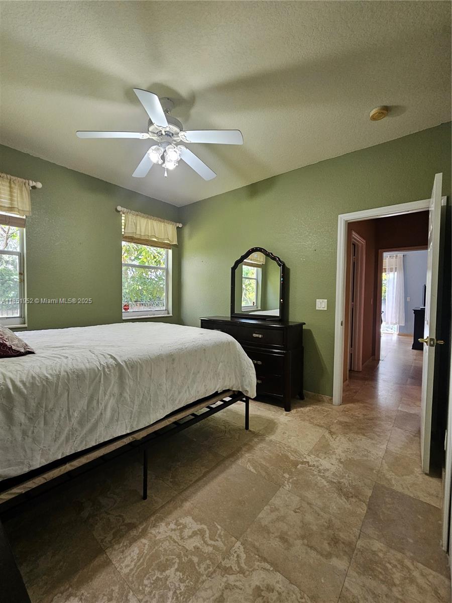18951 Southwest 30th Street Miramar, FL 33029 - Photo 45 of 62 a bedroom with a bed and a chandelier