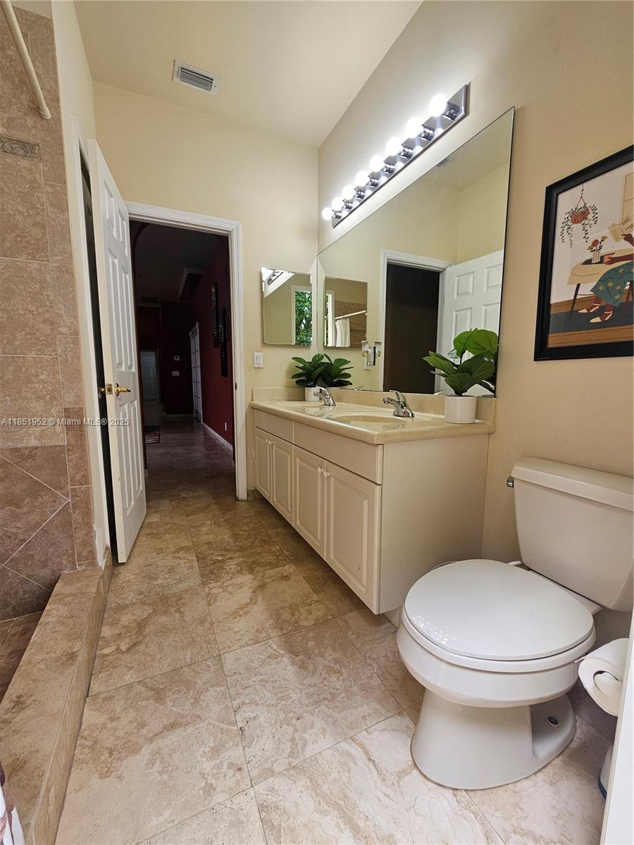 18951 Southwest 30th Street Miramar, FL 33029 - Photo 49 of 62 a bathroom with a toilet sink and mirror