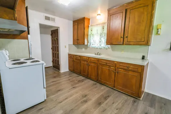 a kitchen with a sink stove and cabinets