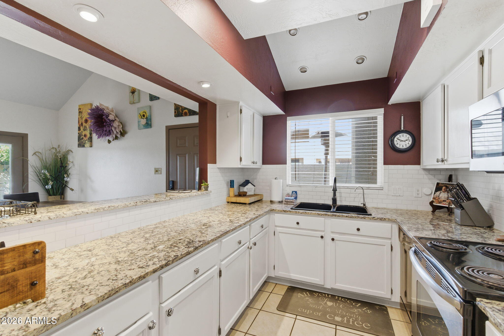 4218 West Boca Raton Road Phoenix, AZ 85053 - Photo 7 of 27 a kitchen with granite countertop a sink stainless steel appliances white cabinets and window