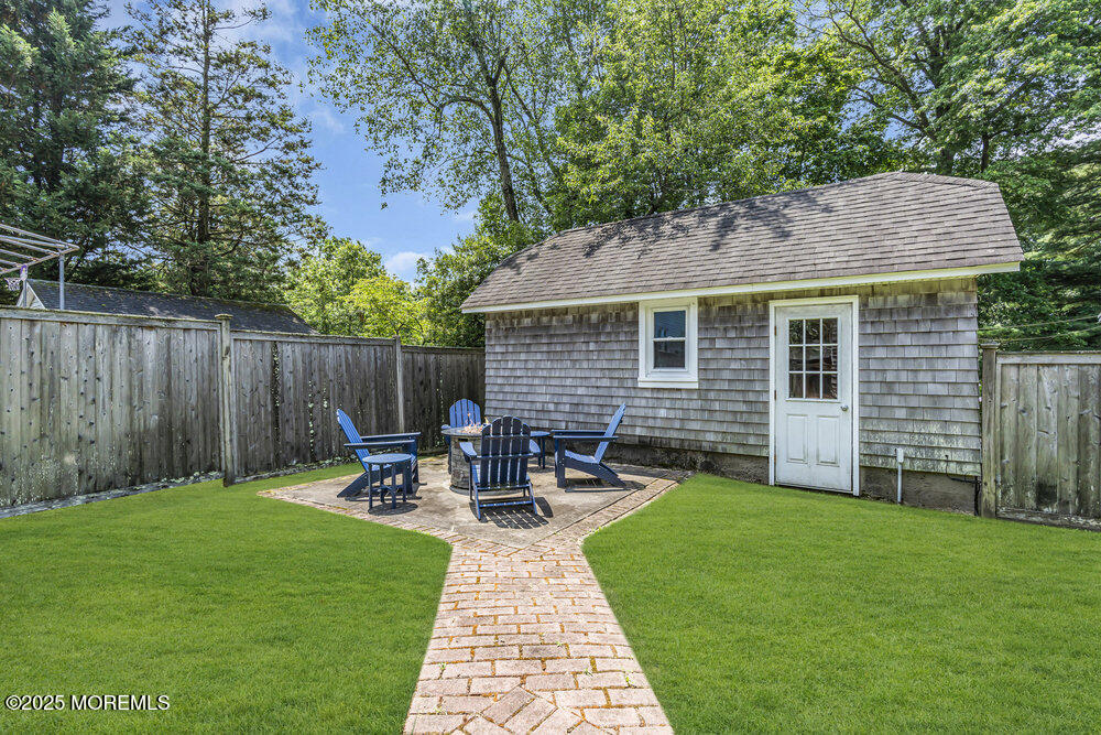 24 Chestnut Street Fair Haven, NJ 07704 - Photo 37 of 42 a view of backyard with table and chairs and wooden fence
