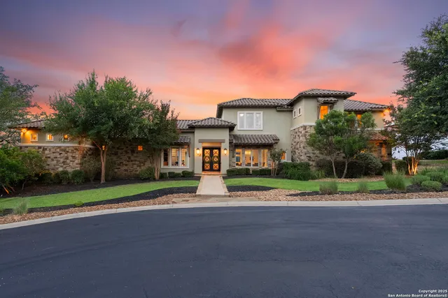 a view of a house with a big yard and large trees