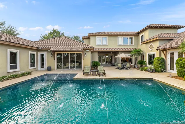 a view of a house with swimming pool and sitting area
