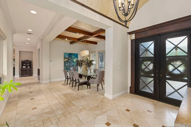 a kitchen with stainless steel appliances kitchen island granite countertop a dining table chairs and a refrigerator