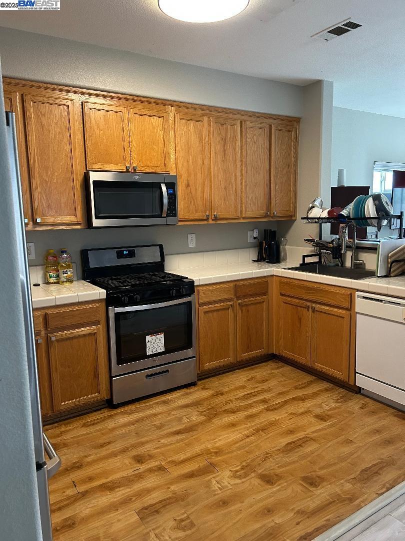 112 Gibson Avenue Bay Point, CA 94565 - Photo 3 of 19 a kitchen with a sink stove and microwave