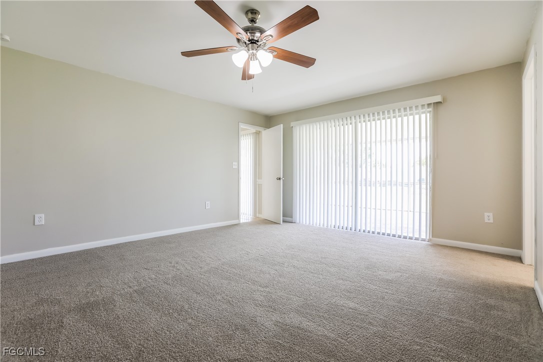 64 Golfview Road Rotonda West, FL 33947 - Photo 9 of 16 an empty room with windows and fan