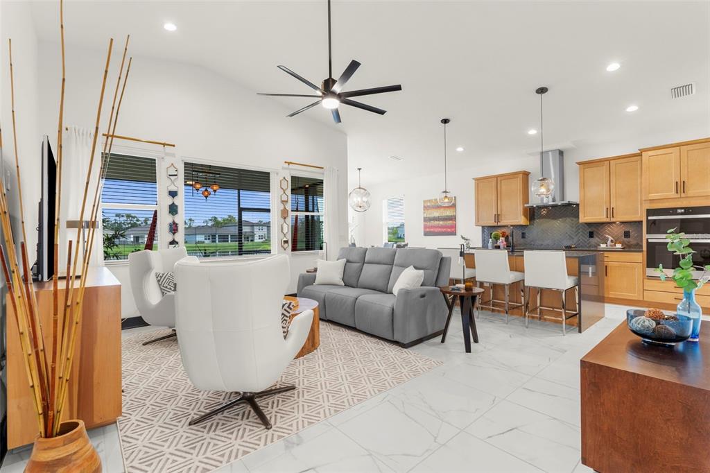 a living room with furniture a rug and kitchen view