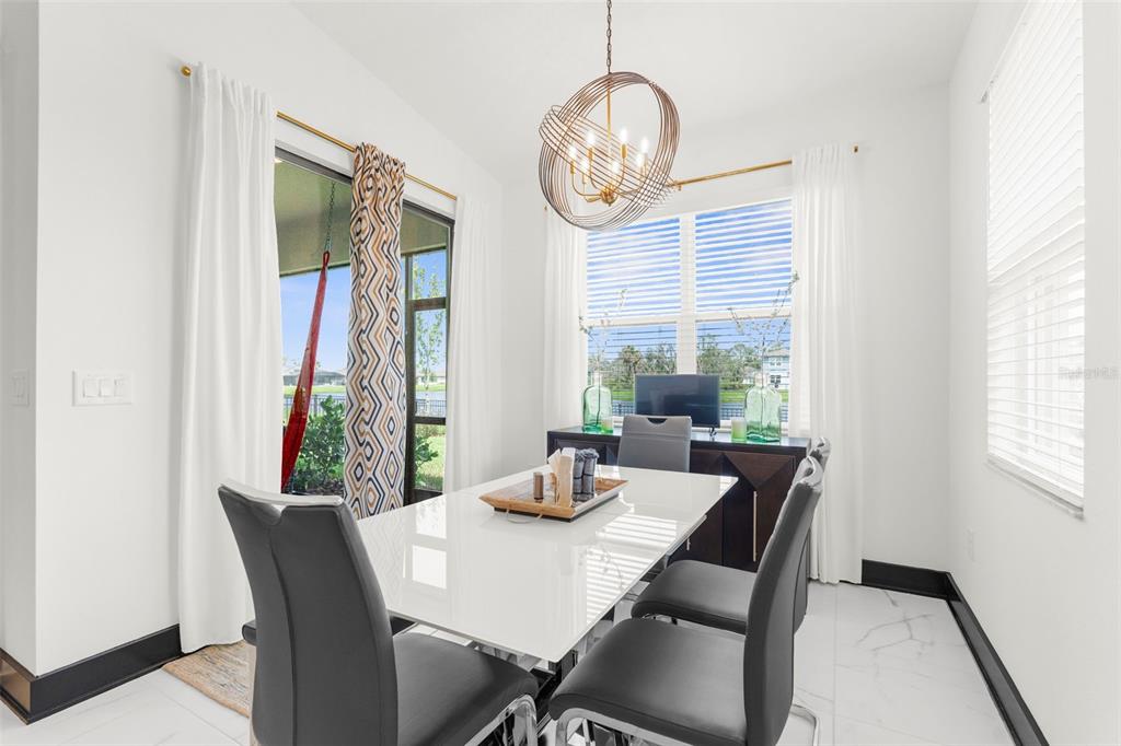 8756 Windlass Cove Palmetto, FL 34221 - Photo 23 of 50 a dining room with furniture a rug a potted plant and a chandelier