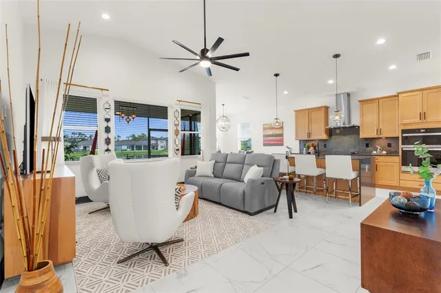 a living room with furniture a rug and kitchen view