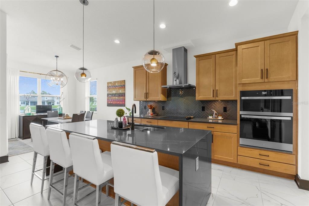 8756 Windlass Cove Palmetto, FL 34221 - Photo 3 of 50 a kitchen with stainless steel appliances a stove a sink a microwave a dining table and chairs