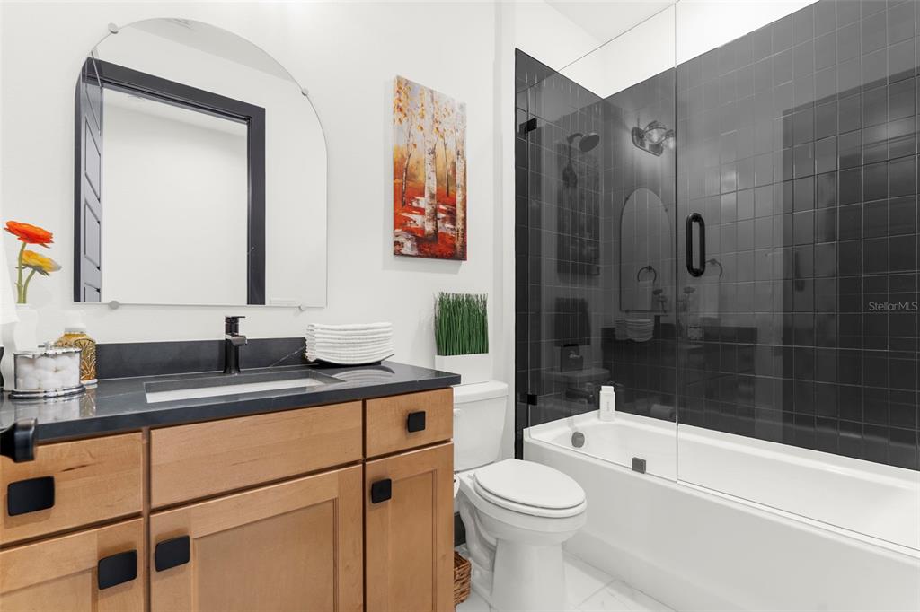 8756 Windlass Cove Palmetto, FL 34221 - Photo 34 of 50 a bathroom with a granite countertop sink a toilet a mirror a vanity and shower