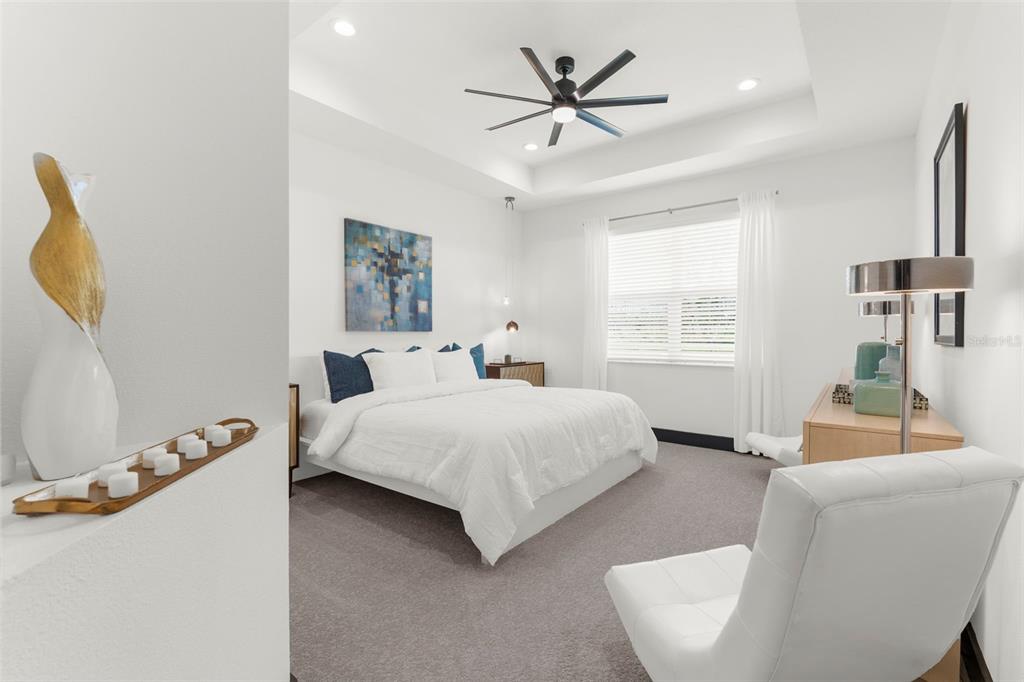 8756 Windlass Cove Palmetto, FL 34221 - Photo 44 of 50 a spacious bedroom with a bed a couch and a window