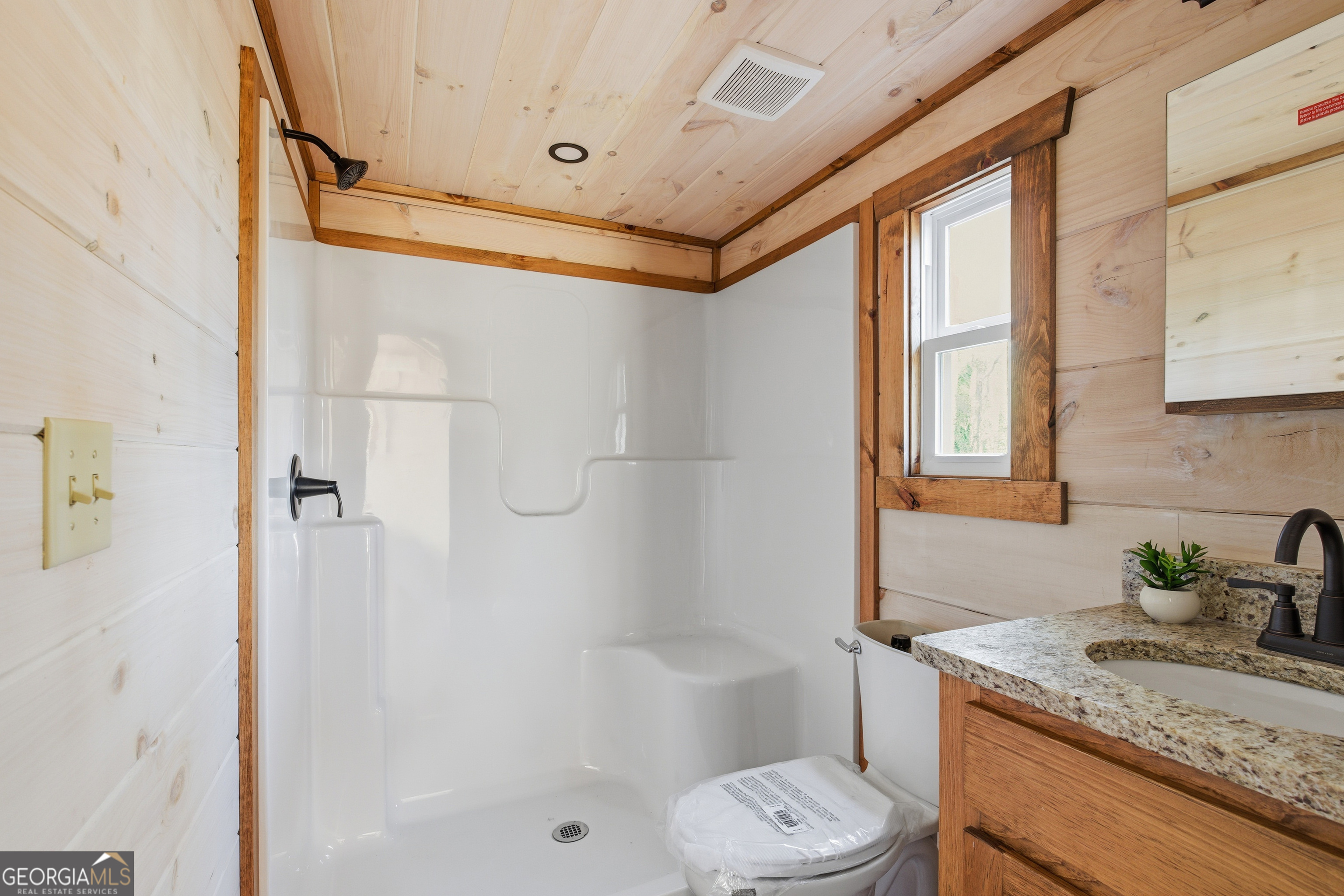 527 Saunders Road Franklin, NC 28734 - Photo 17 of 19 a bathroom with a granite countertop sink a toilet and shower