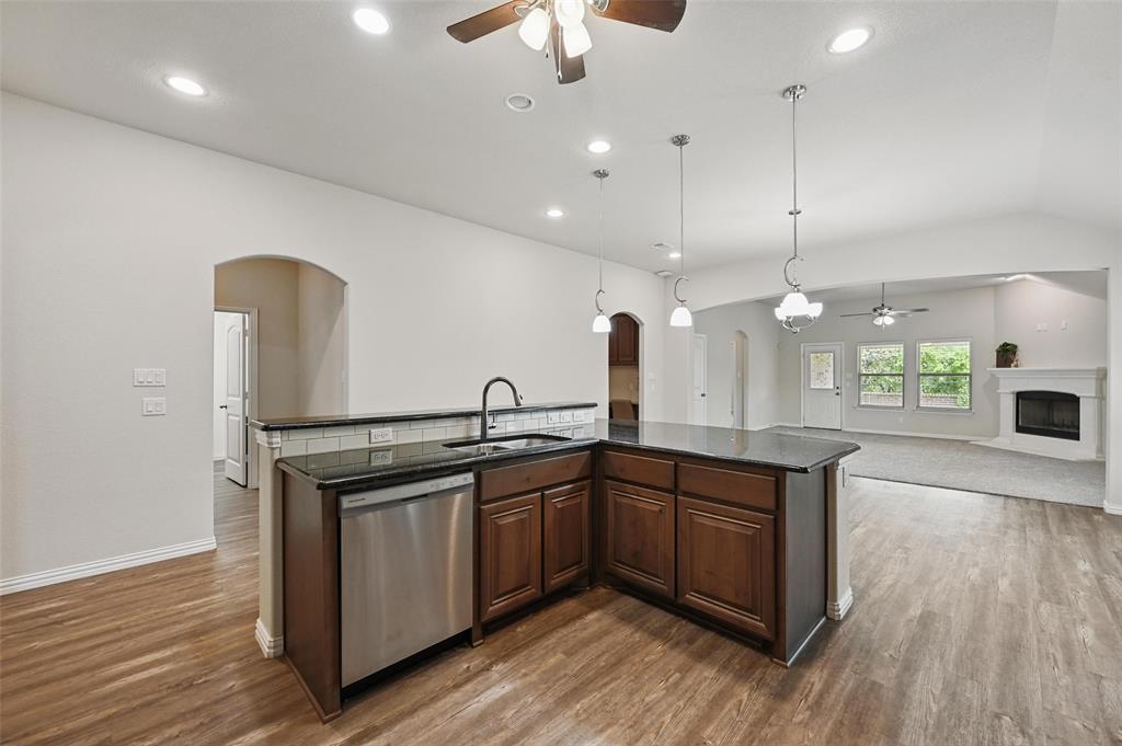 512 Hidden Spgs Trail Azle, TX 76020 - Photo 26 of 27 a kitchen with stainless steel appliances granite countertop a sink a stove and wooden floor