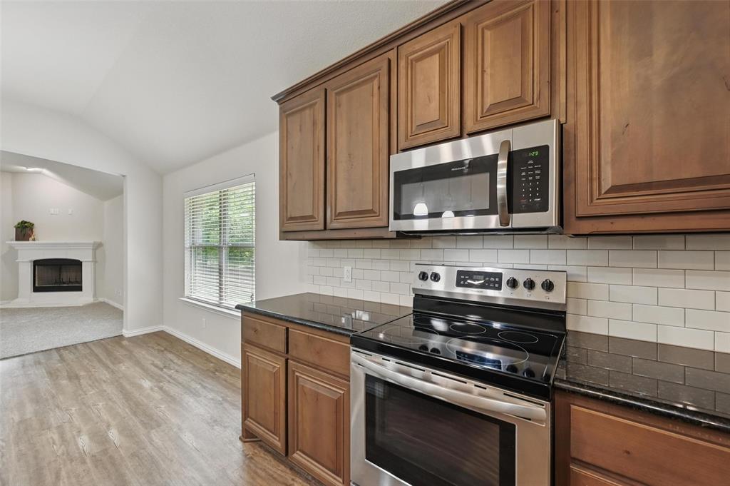 512 Hidden Spgs Trail Azle, TX 76020 - Photo 5 of 27 a kitchen with stainless steel appliances granite countertop a stove a microwave and cabinets