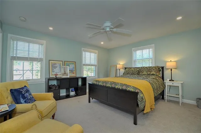 a spacious bedroom with a bed couch and window