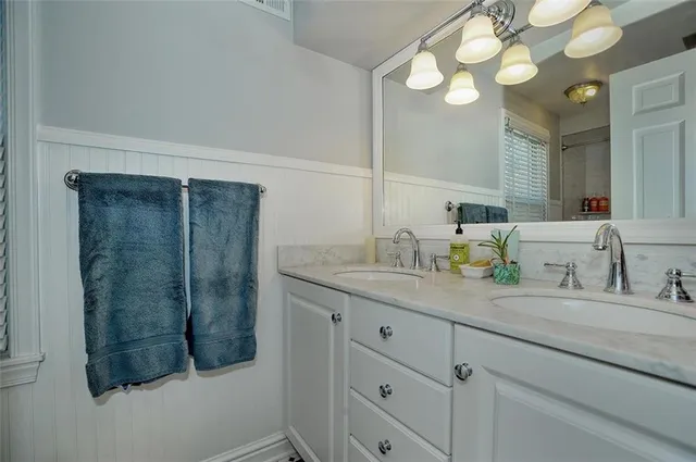 a bathroom with a sink vanity granite and a mirror